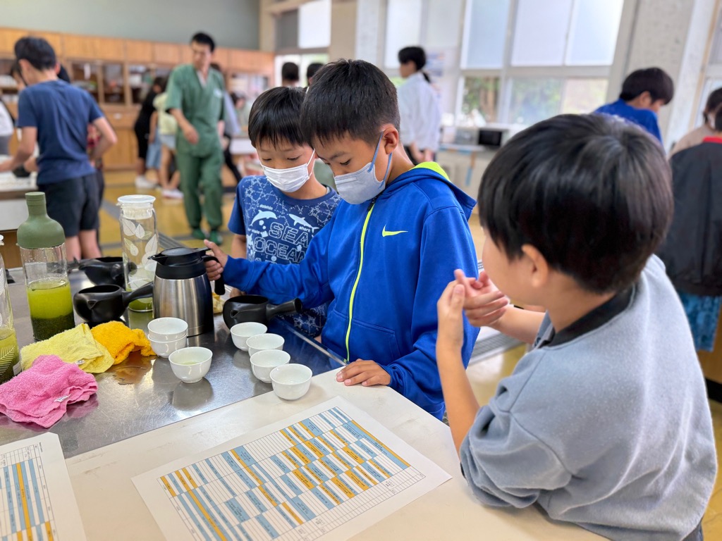 小学生男子3人が配布されたセリフプリントを見ながら流れの練習をしている