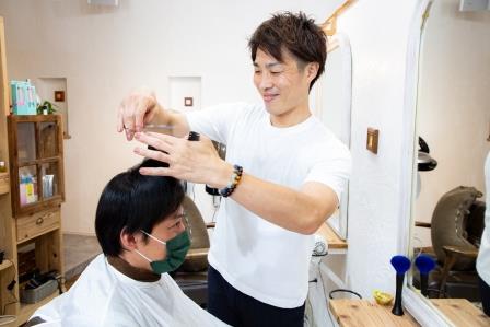 久保田秀明さんがお客さんをカットしている様子