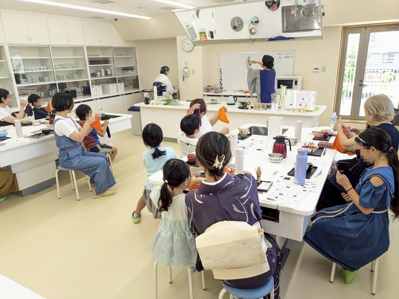 調理室で親子がふくさの使い方を学んでいる
