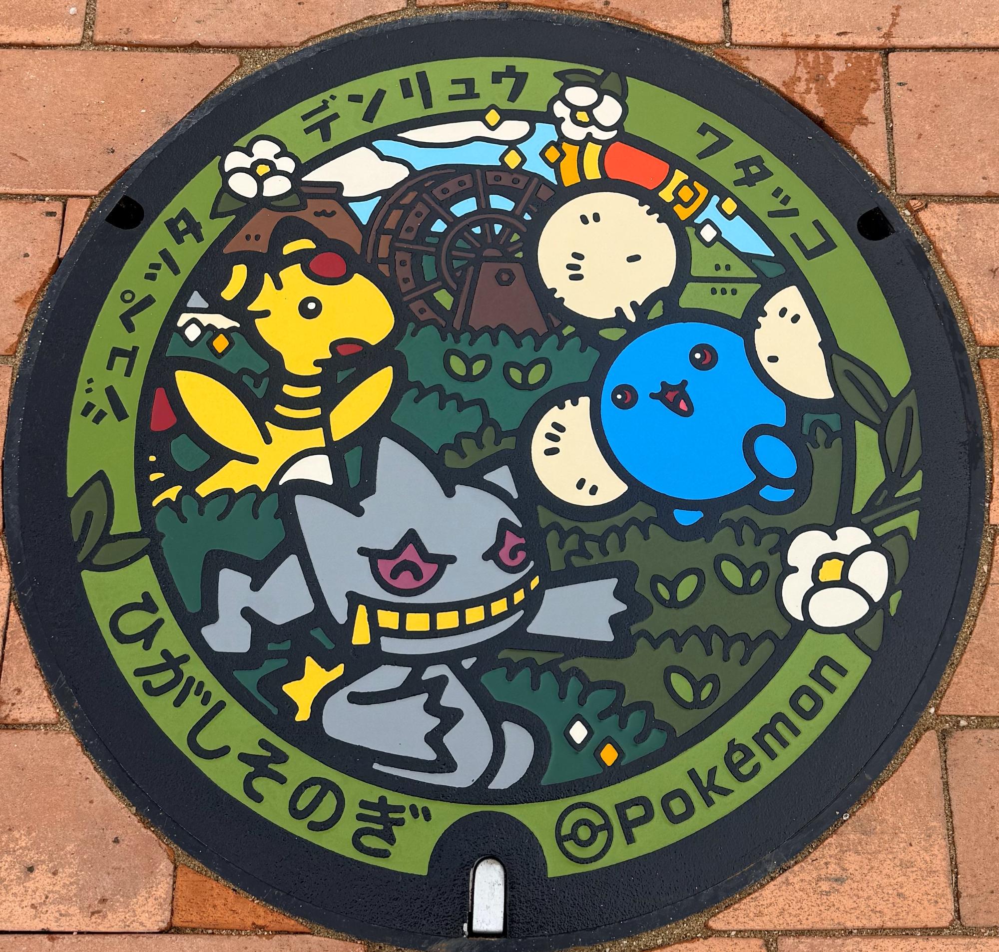 東彼杵町に設置されている、ポケふた。お茶畑を背景に、デンリュウ、ワタッコ、ジュペッタが描かれています。