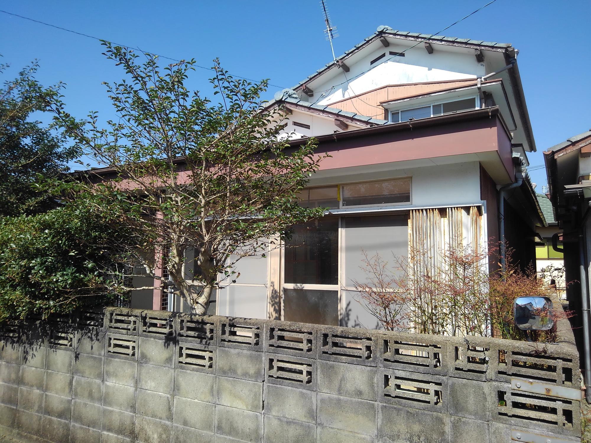 物件番号69番の外観。玄関横に2階建てで小さな庭がある。