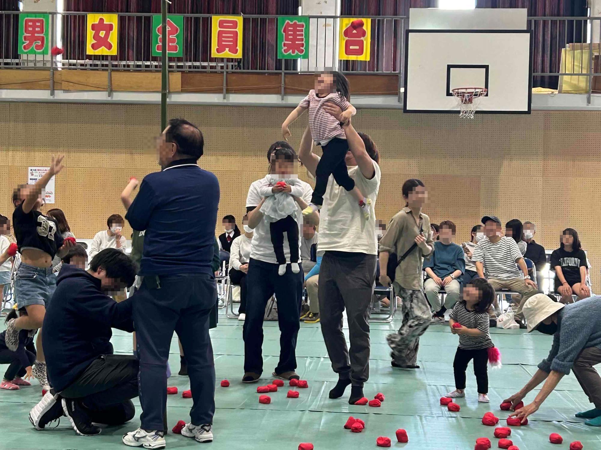 多世代の人が集まって玉入れを楽しんでいる