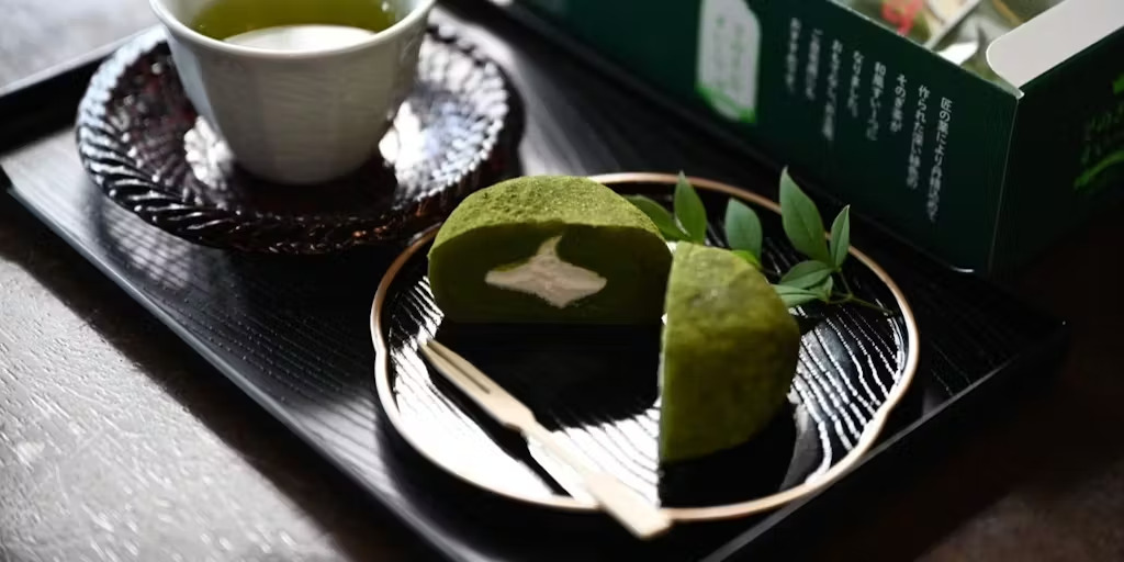 お盆の上にそのぎ茶とお茶の生地にクリームを包んだお菓子が置かれている