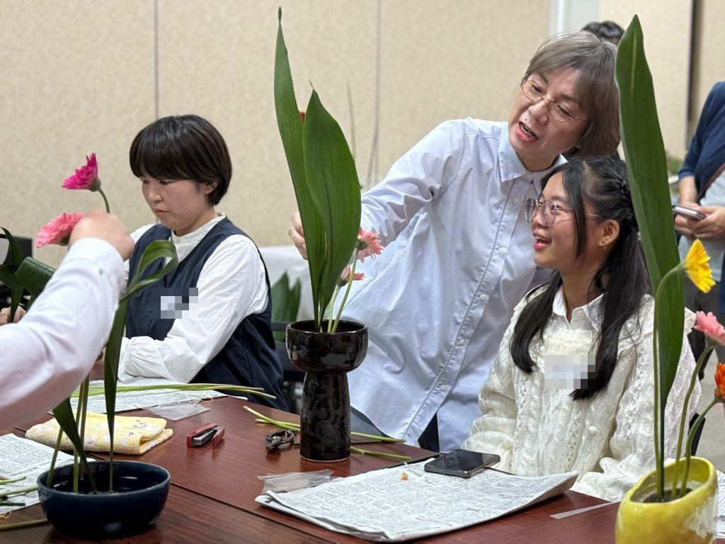 生けた花の意見を聞く女性