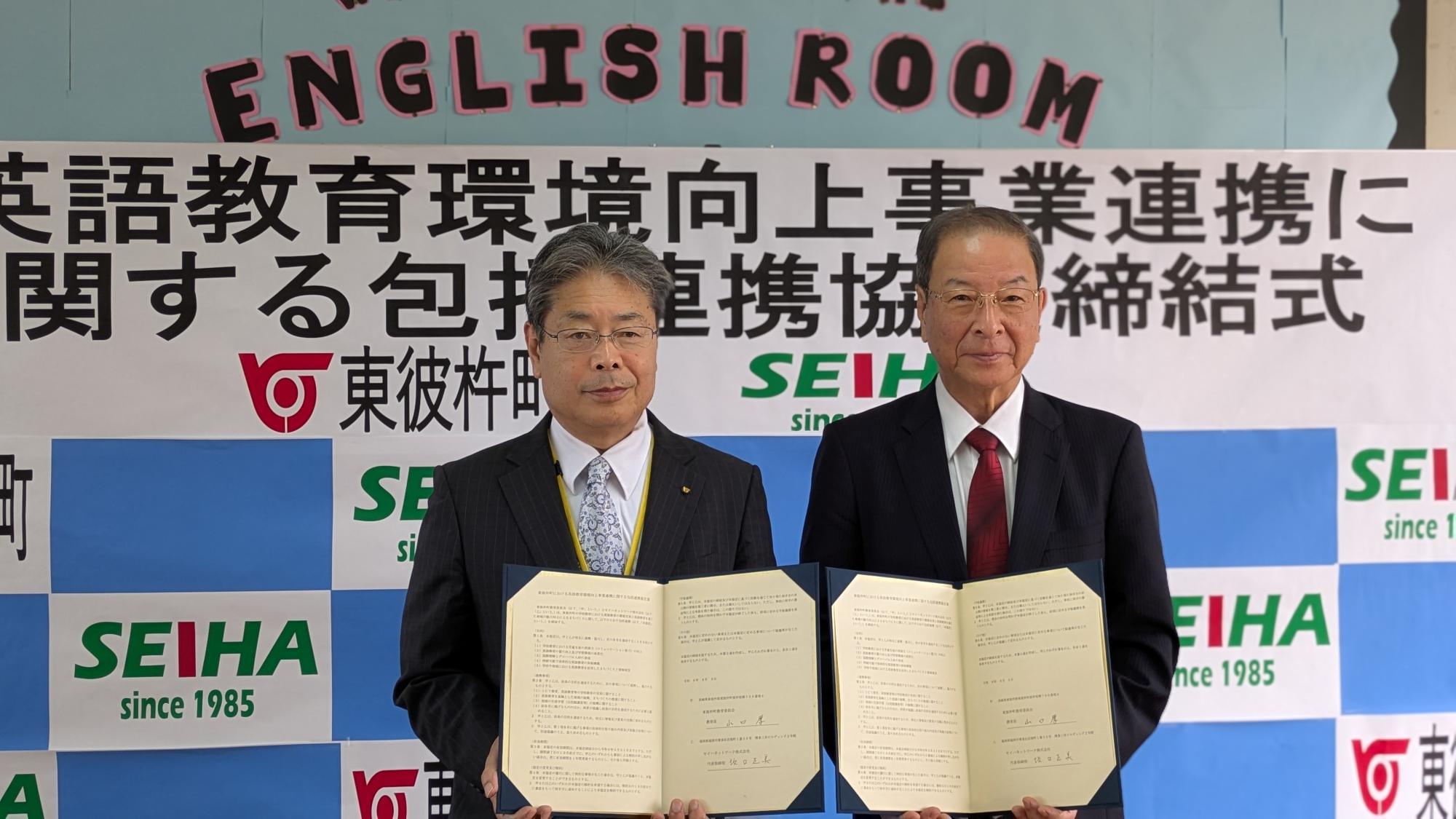 東彼杵町教育長の山口厚とセイハネットワーク株式会社代表取締役社長の坂口正美が包括連携協定書を持って並んだ締結式の写真